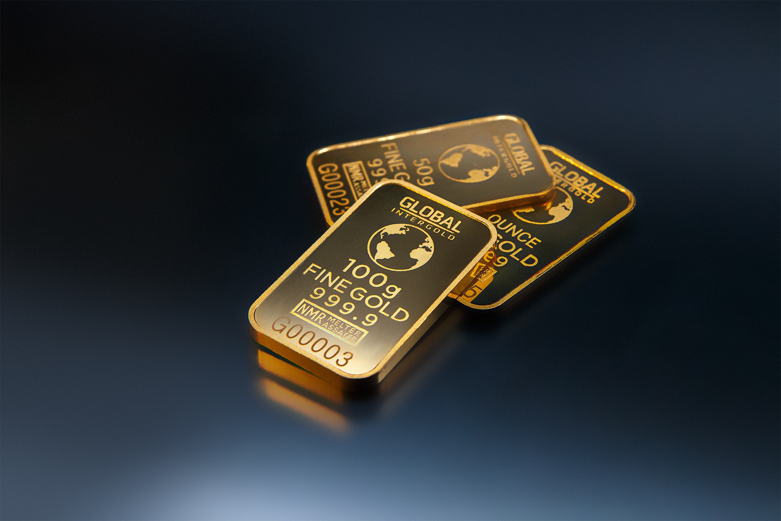 three-gold-bars-against-dark-background-321452.jpg