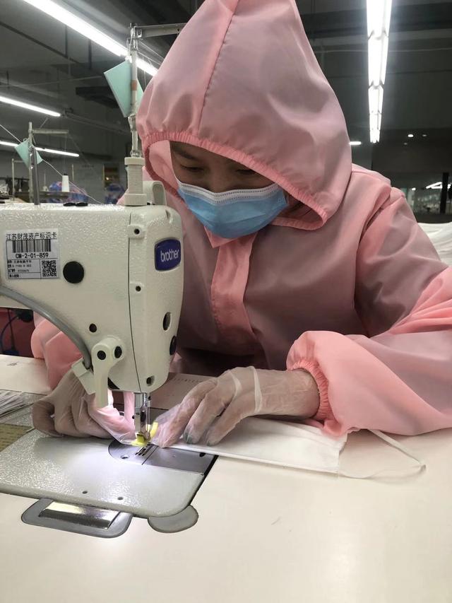 图为淘帝一线工人用针车手工缝制口罩.